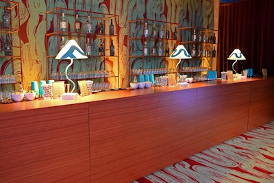 The team opted for an event design that transformed the venue into a midcentury loft-inspired nightclub utilizing wood paneling, floral installations, and eclectic patterns.