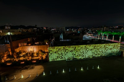 Along with olive trees, abstract tree branches accented the space and were projected onto an 80-foot-long main entry wall, giving off a soft, amber glow.