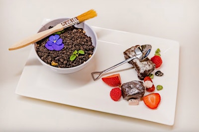 For a fundraiser at the Frost Science Museum in Miami, Constellation Culinary Group created a dinosaur-inspired menu with hidden “fossils” and grazing stations. The interactive dessert (pictured) featured chocolate “fossils” nestled underneath gold dust. Guests were instructed to use the fossil brush to brush aside the dust and edible mini garden to discover a slew of sweet fossils and edible rocks. See more: This Catering Team Amped Up an Event Theme with a Clever Menu That Guests Really 'Dug'